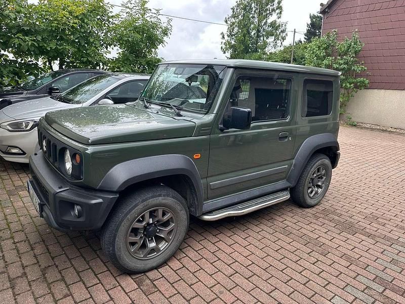 Grün Gebraucht 2019 Suzuki Jimny Comfort+ SUV | 28.500 € (Fairer Preis) - Bild 1/4