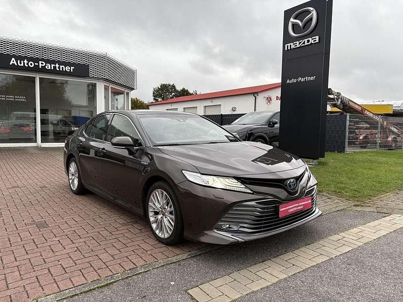 Grau Gebraucht 2020 Toyota Camry Hybrid Executive Limousine | 26.990 € - Bild 1/4