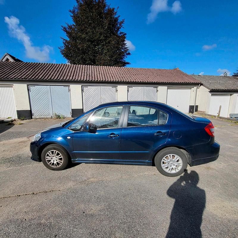 Blau Gebraucht 2009 Suzuki SX4 Limousine | 4.900 € (Superpreis) - Bild 1/4