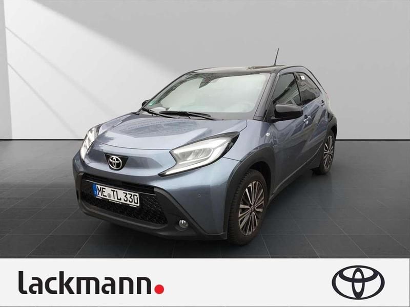 Celestite grey (1k3)/ black mi Gebraucht 2024 Toyota Aygo Comfort Kleinwagen | 16.990 € (Fairer Preis) - Bild 1/4