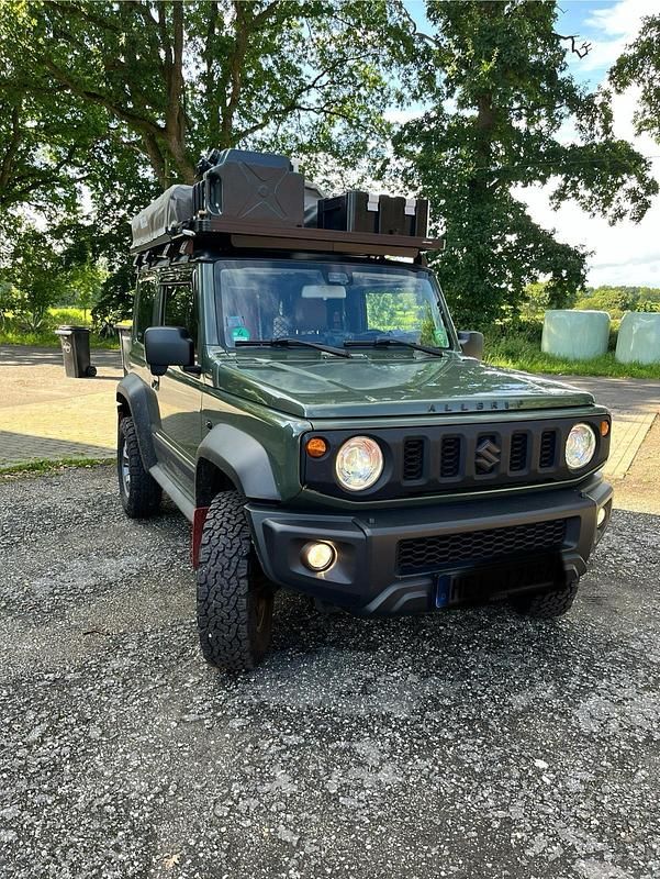 Grün Gebraucht 2020 Suzuki Jimny Comfort+ SUV | 32.999 € (Teuer) - Bild 1/4