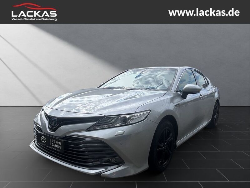 Silver metallic (metallic) Gebraucht 2020 Toyota Camry Hybrid Executive Limousine | 27.990 € - Bild 1/4