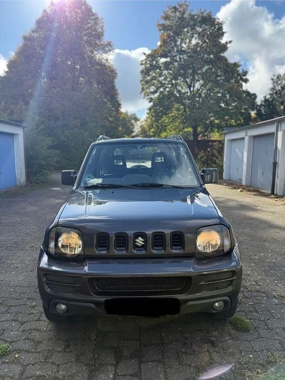 Grau Gebraucht 2012 Suzuki Jimny Style SUV | 5.900 € (Fairer Preis) - Bild 1/4