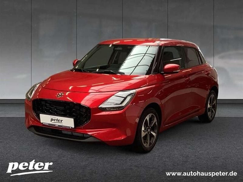 Burning red pearl met. Neu 2025 Suzuki Swift Comfort+ Kleinwagen | 22.840 € - Bild 1/4