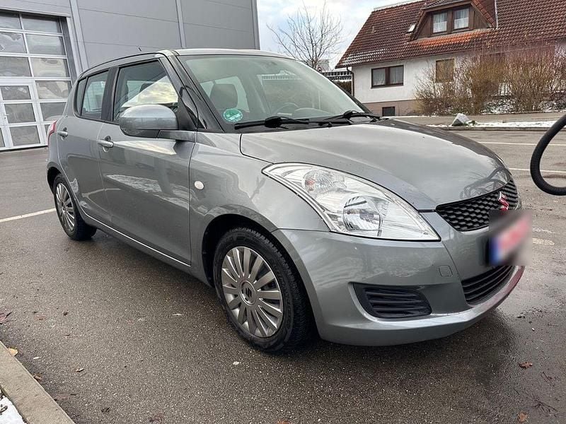 Grau Gebraucht 2013 Suzuki Swift Comfort Limousine | 6.350 € (Fairer Preis) - Bild 1/4