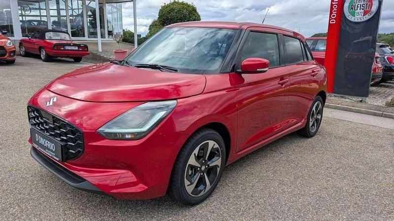 Burning red pearl metallic Neu 2025 Suzuki Swift Comfort+ Kleinwagen | 21.490 € - Bild 1/4