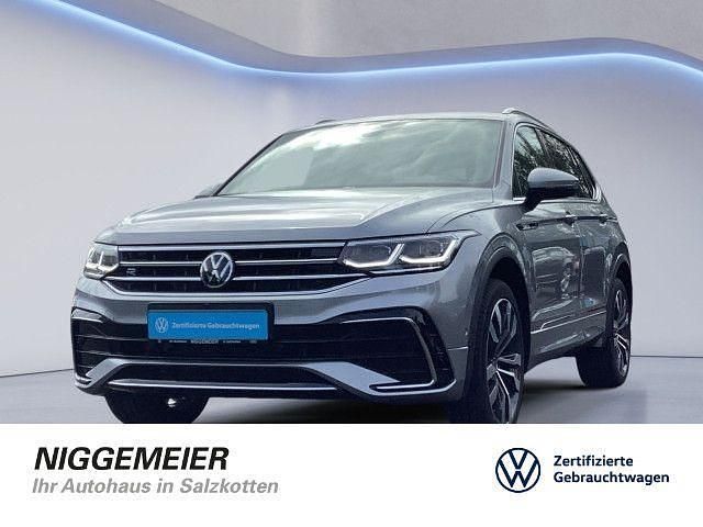 Pyritsilber metallic (metallic) Gebraucht 2023 VW Tiguan Allspace R-line SUV | 39.480 € (Fairer Preis) - Bild 1/4