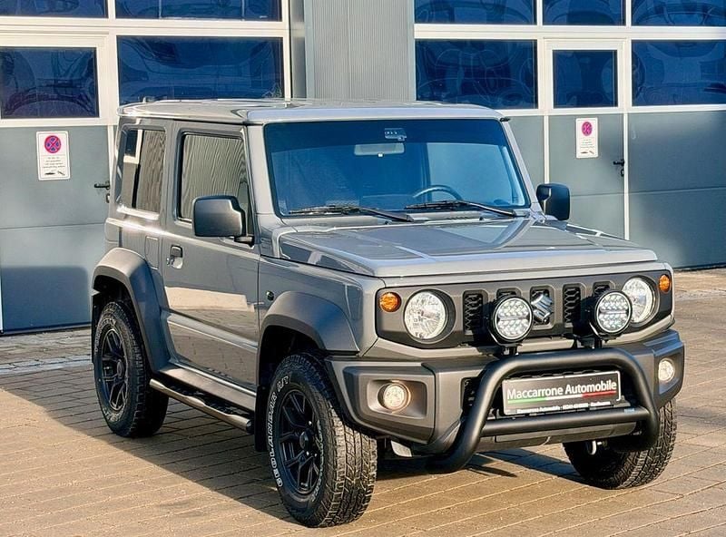 Medium grey (metallic) Gebraucht 2024 Suzuki Jimny SUV | 38.990 € (Teuer) - Bild 1/4