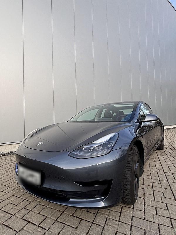 Grau Gebraucht 2022 Tesla Model 3 Standard Range Plus Limousine | 28.990 € (Superpreis) - Bild 1/4