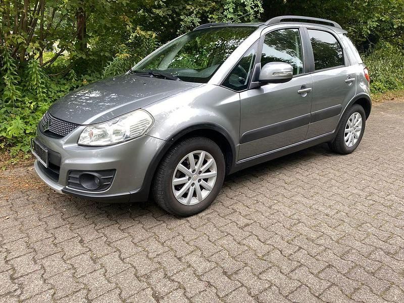 Grau Gebraucht 2011 Suzuki SX4 Comfort Limousine | 4.850 € (Fairer Preis) - Bild 1/4