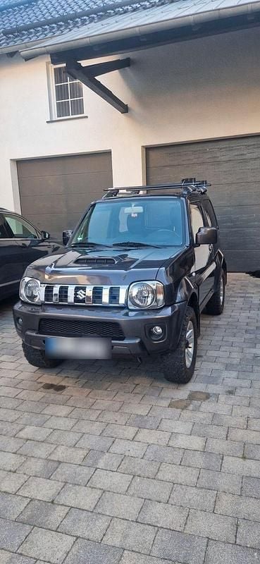 Grau Gebraucht 2012 Suzuki Jimny Style SUV | 10.900 € (Fairer Preis) - Bild 1/4