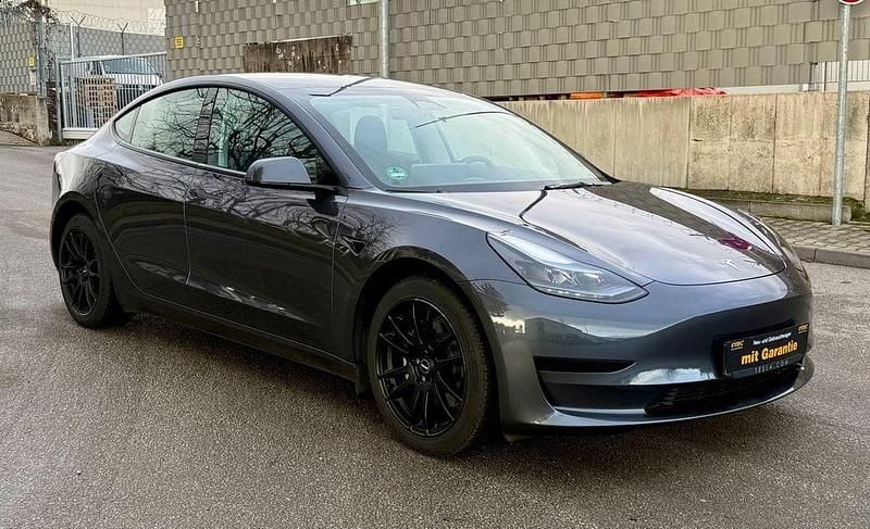 Grau Gebraucht 2022 Tesla Model 3 Standard Range Plus Limousine | 24.990 € - Bild 1/4