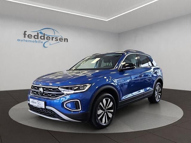 Ravennablau metallic (metallic) Gebraucht 2024 VW T-Roc Goal SUV | 24.881 € (Guter Preis) - Bild 1/4