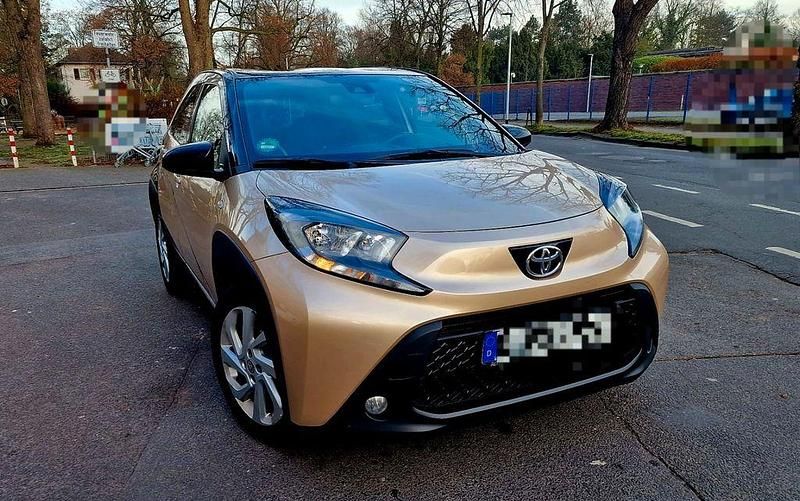 Gold Gebraucht 2022 Toyota Aygo X-plore Kleinwagen | 12.390 € - Bild 1/4