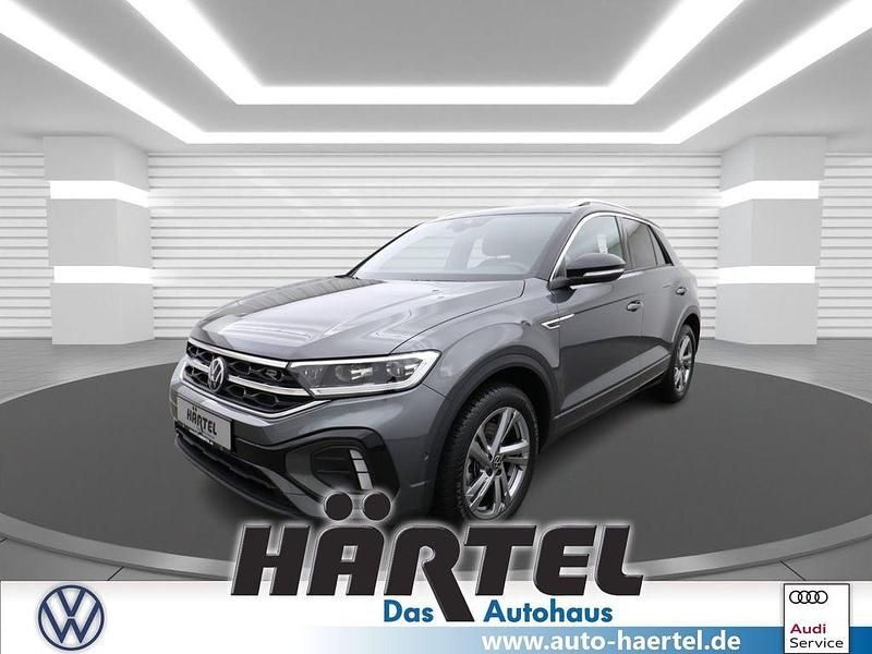 Indiumgrau (grey), metallic Gebraucht 2024 VW T-Roc R-line SUV | 30.700 € (Guter Preis) - Bild 1/4
