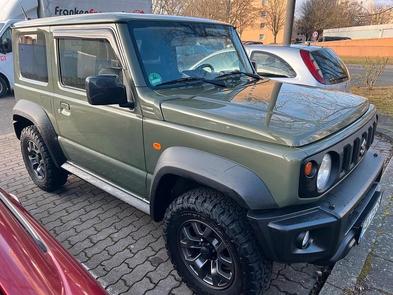 Grün Gebraucht 2019 Suzuki Jimny Comfort+ SUV | 25.650 € (Fairer Preis) - Bild 1/4