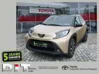 Gebraucht Toyota Aygo Pulse 72 PS (52 kW) 2023 Ginger beige (4u9)/ black mica (209) (metallic) Kleinwagen