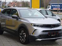 Gebraucht Opel Mokka-e Elegance 100 kW (136 PS) 2022 Kontrast grauquarz silber (metallic) SUV