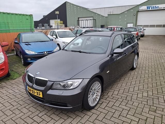 Grijs (metallic) Gebruikt 2007 BMW 325 Executive Stationwagen | € 3.995 (Super prijs) - Afbeelding 1/4