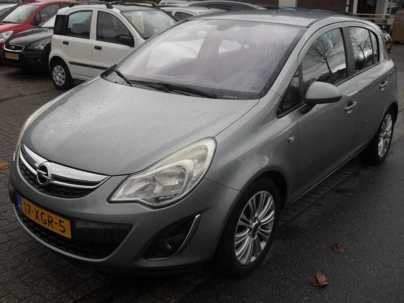 Grijs (metallic) Gebruikt 2012 Opel Corsa Cosmo Hatchback | € 2.650 (Goede deal) - Afbeelding 1/4