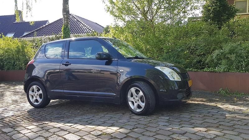 Zwart (metallic) Gebruikt 2005 Suzuki Swift GLS Hatchback | € 2.649 (Eerlijke prijs) - Afbeelding 1/4