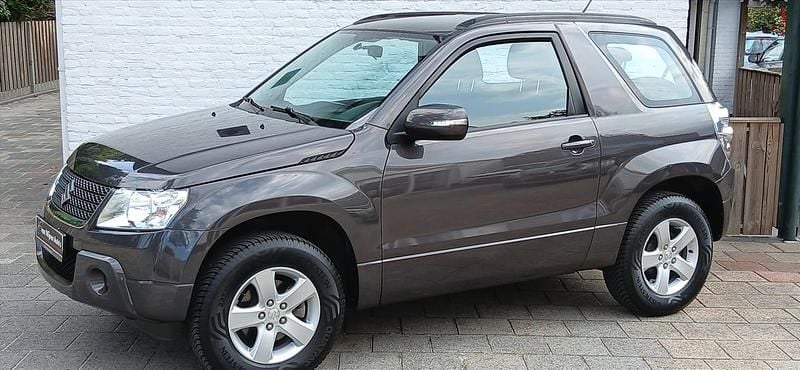 Grijs, metallic lak Gebruikt 2012 Suzuki Grand Vitara Exclusive SUV | € 15.949 - Afbeelding 1/4
