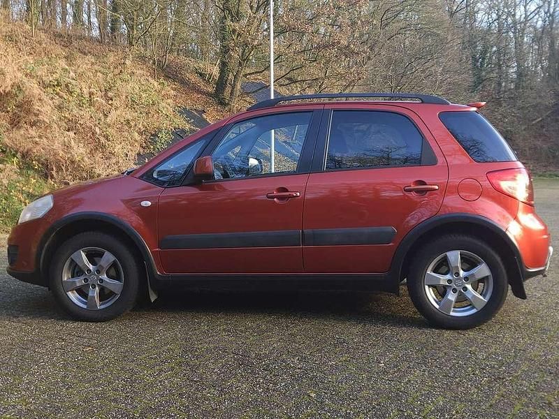 Oranje (metallic) Gebruikt 2010 Suzuki SX4 Exclusive MPV | € 2.500 - Afbeelding 1/4