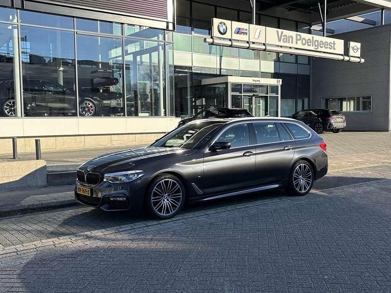 Grijs (metallic) Gebruikt 2018 BMW 520 Executive Stationwagen | € 23.950 (Goede deal) - Afbeelding 1/4
