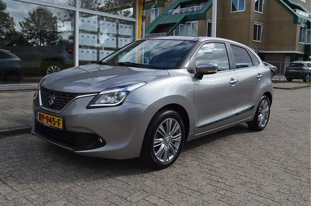 Grijs, metallic lak Gebruikt 2018 Suzuki Baleno Hatchback | € 10.900 (Eerlijke prijs) - Afbeelding 1/4