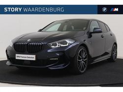 Carbonschwarz (donker zwart metallic) Gebruikt 2022 BMW 118 Shadowline Hatchback | € 29.950 (Duur)