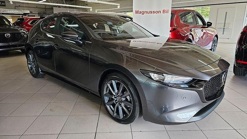 Grå (machine grey metallic ) Ny 2025 Mazda 3 Center-Line Halvkombi | 337 400 kr (Marknadspris) - Bild 1/3