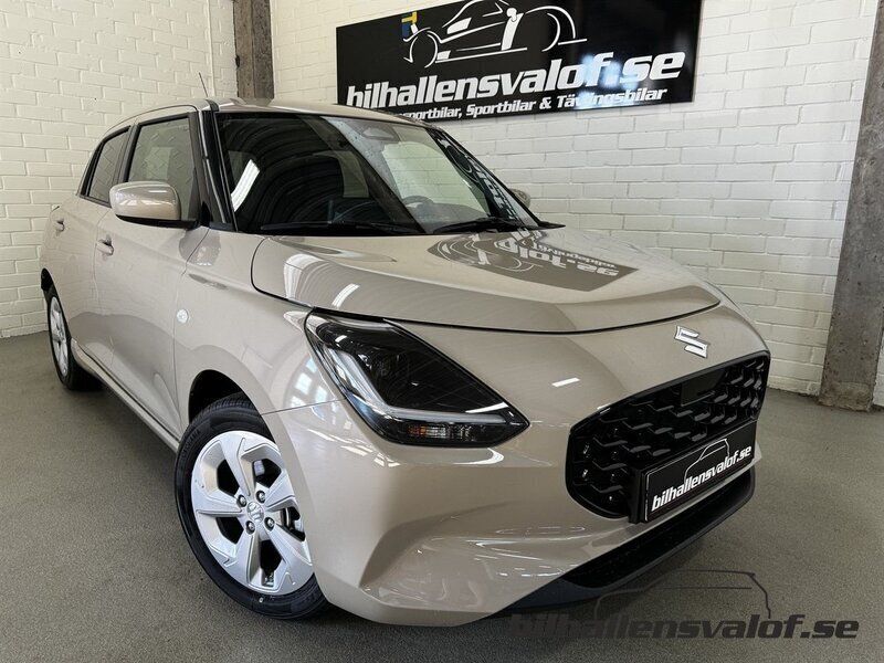 Brun (caravan ivory pearl metallic) Ny 2024 Suzuki Swift Halvkombi | 241 400 kr (Marknadspris) - Bild 1/4