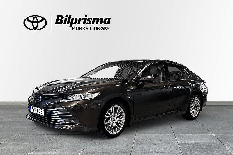 Mörkbrun Begagnad 2019 Toyota Camry Hybrid Executive Sedan | 239 900 kr (Marknadspris) - Bild 1/3
