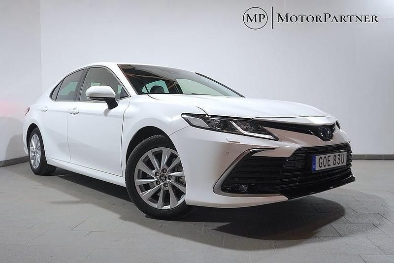 Vit Begagnad 2023 Toyota Camry Hybrid Executive Sedan | 329 900 kr (Bra pris) - Bild 1/4