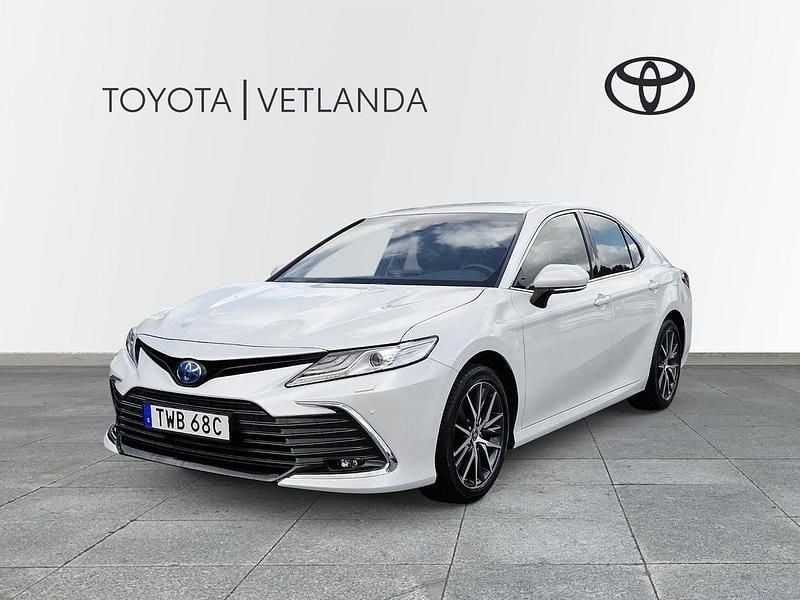 Vit (white pearl metallic) Begagnad 2022 Toyota Camry Hybrid Executive Sedan | 309 000 kr (Marknadspris) - Bild 1/3