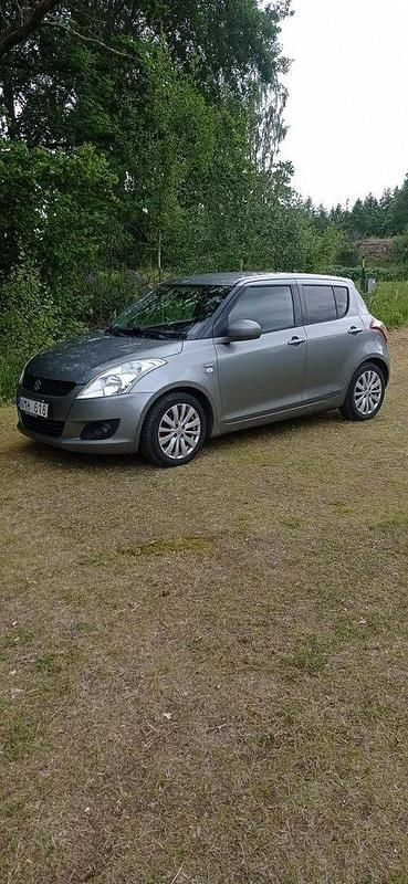 Grå Begagnad 2013 Suzuki Swift Halvkombi | 63 000 kr (Marknadspris) - Bild 1/3