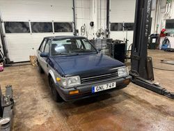 Halv blå halv svart Begagnad 1985 Mazda 323 Sedan | 18 000 kr