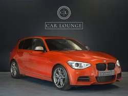 Orange (valencia orange metallic) Begagnad 2014 BMW M135 Comfort Edition Halvkombi | 259 000 kr (Marknadspris)